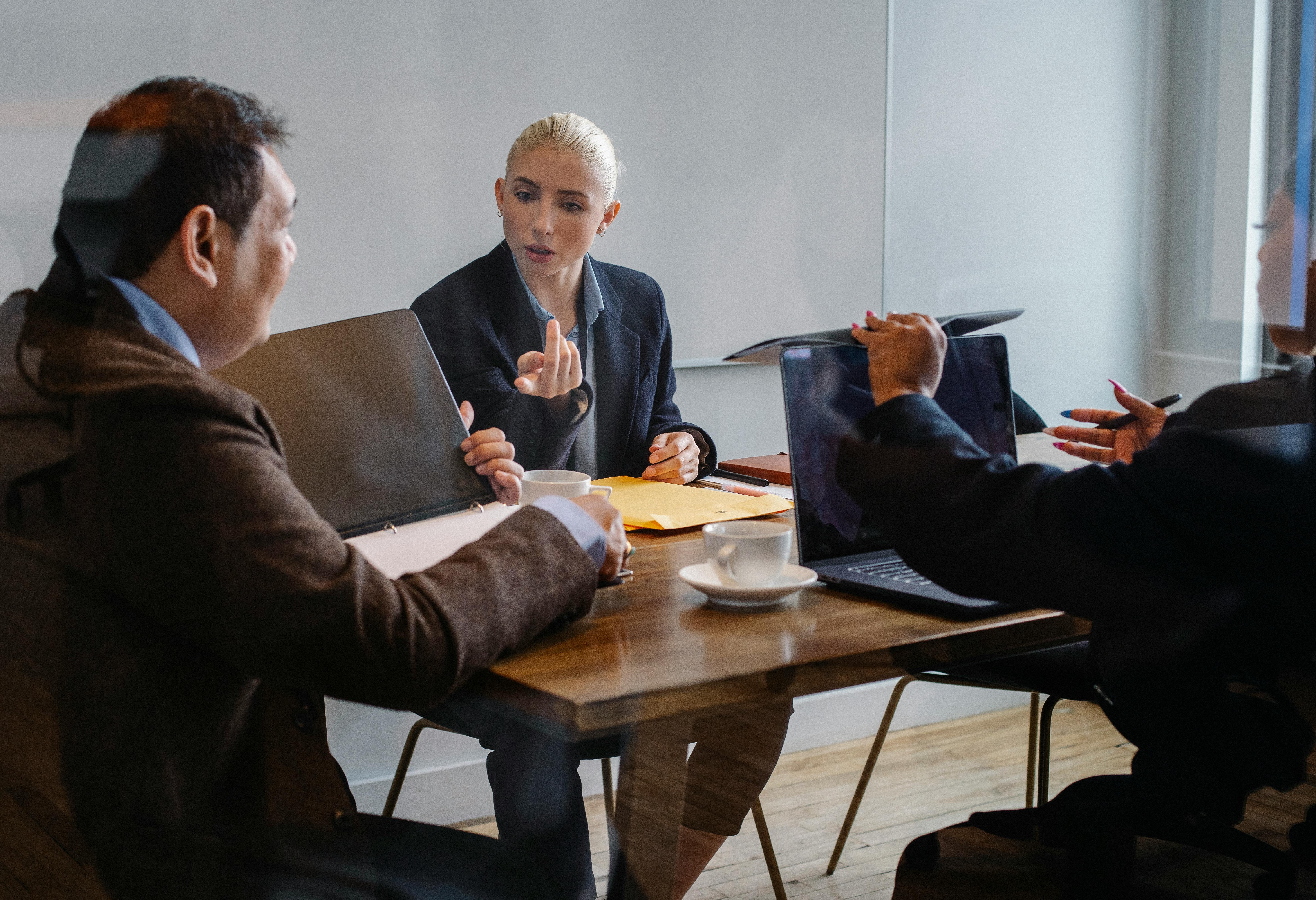A diverse group of professionals collaborating during a business meeting in an office setting.