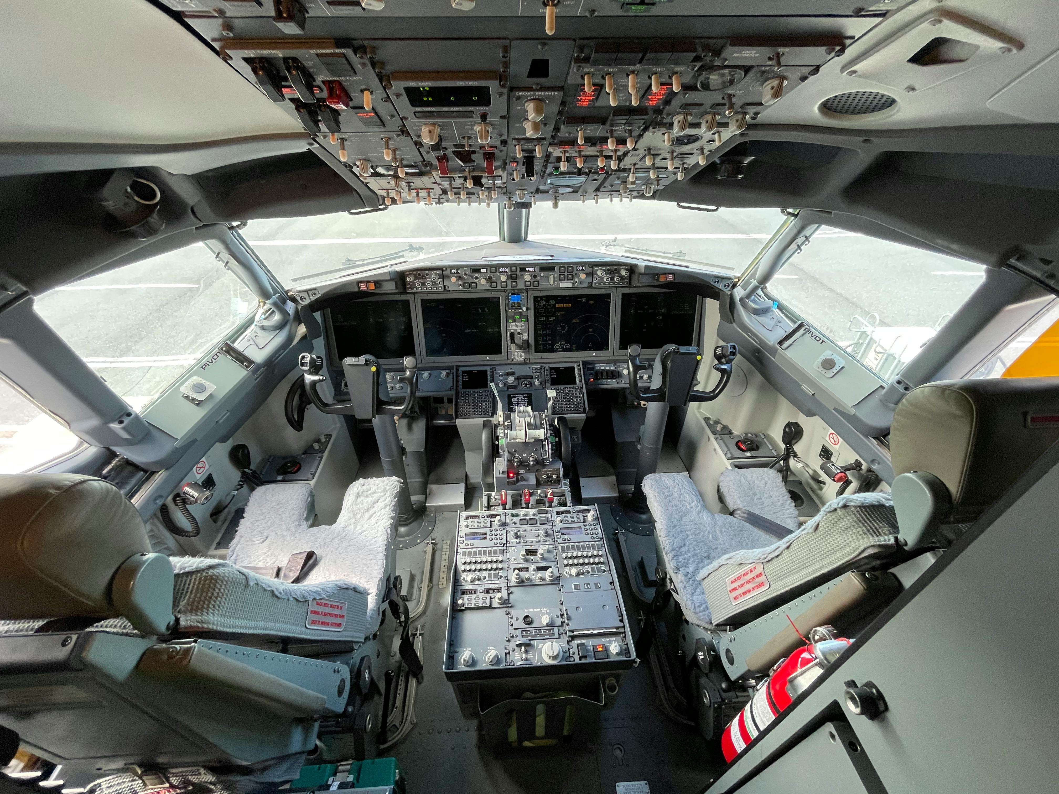 Interior view of a modern commercial aircraft cockpit featuring advanced flight controls.